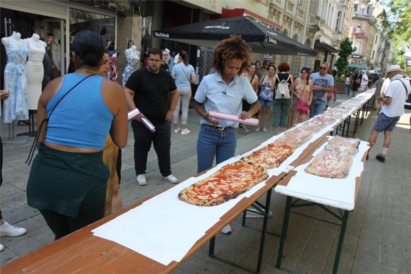 Noch etwas gedulden, bitte: Bis zum Abmessen und Verzehr wurde die Pizza mit Pla...
