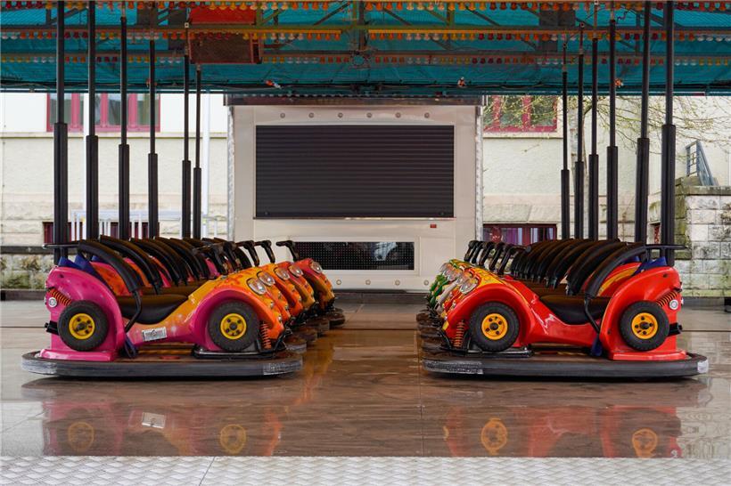 Autoscooter auf Jahrmarkt stehen still, bereit für Fahrspaß ab Freitagnachmittag, leuchtende Lichter und Fahrfläche sichtbar