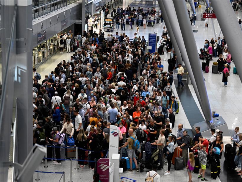 Nordrhein-Westfalen, Düsseldorf: Reisende stehen in Schlangen vor den Check-In-Schaltern im Terminal. Wegen des Verdi-Warnstreiks hat die Lufthansa für Mittwoch (27.07.2022) nahezu ihren kompletten Flugplan abgesagt. 
