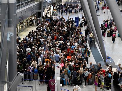 Nordrhein-Westfalen, Düsseldorf: Reisende stehen in Schlangen vor den Check-In-Schaltern im Terminal. Wegen des Verdi-Warnstreiks hat die Lufthansa für Mittwoch (27.07.2022) nahezu ihren kompletten Flugplan abgesagt. 

