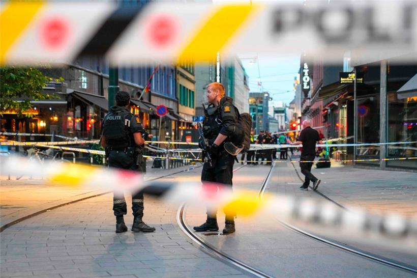 Norwegische Polizeibeamte stehen am Samstag in den Straßen des Osloer Stadtzentrums zwischen Absperrbändern Wache, nachdem vor einem Pub Schüsse abgefeuert worden waren
