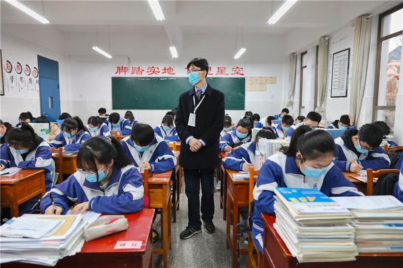 Oberstufenschüler sitzen mit Mundschutzmasken in einem Klassenzimmer der Middle School in der Südwestchinesischen Provinz Guizhou
