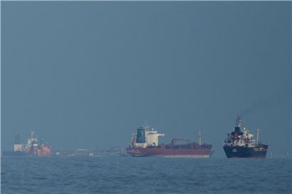 Öltanker und Frachtschiffe aufgereiht in der strategisch wichtigen Straße von Hormus bei klarem Himmel