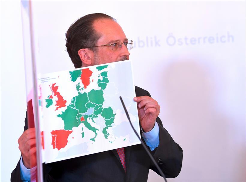Österreichs Außenminister Alexander Schallenberg zeigt auf einer Karte, in welchen Ländern seine Landsleute Urlaub machen dürfen und wo nicht

