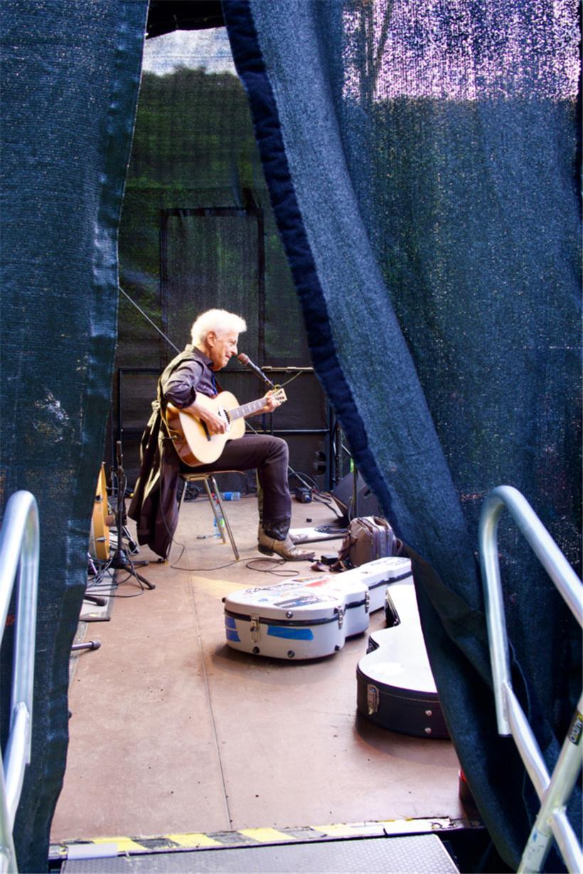 Ohne viel Tamtam, nur mit seiner Gitarre sitzt Doug McLeod auf der Bühne im Fond...