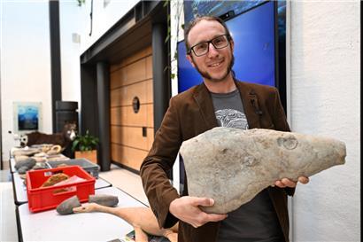 Paläontologe Ben Thuy mit dem Kopf eines Fischsauriers

