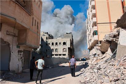 Palästinenser beobachten, wie Rauch aus einem Gebäude aufsteigt, das von einem israelischen Angriff getroffen wurde
