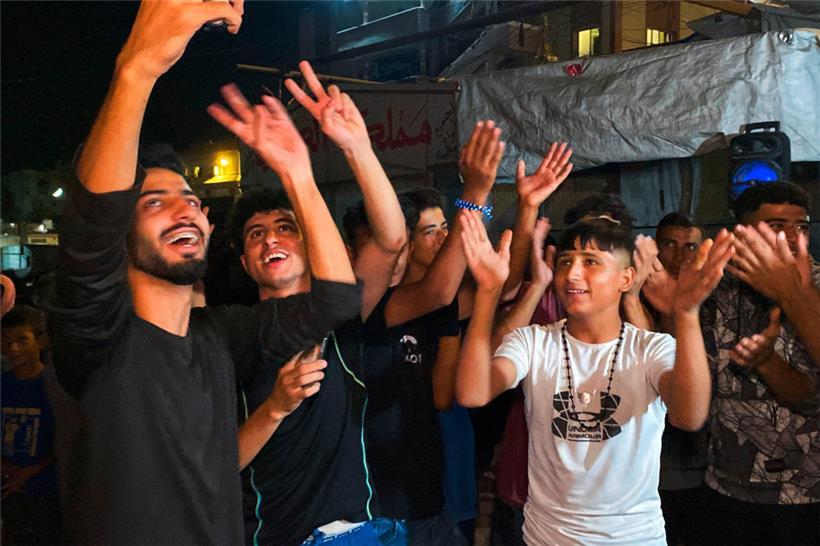 Palästinenser feiern am 9. Oktober in Chan Junis, nachdem die Nachricht über eine neue Waffenstillstandsvereinbarung für Gaza bekannt wurde
