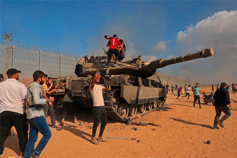 Palästinenser feiern die Erbeutung eines israelischen Panzers am Grenzübergang Khan Yunis im Süden des Gazastreifens
