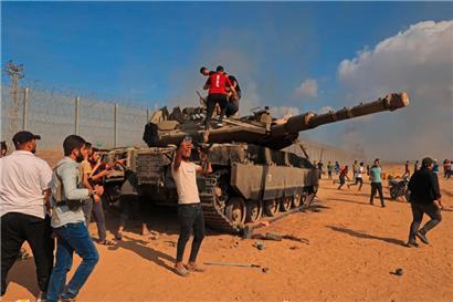 Palästinenser feiern die Erbeutung eines israelischen Panzers am Grenzübergang Khan Yunis im Süden des Gazastreifens

