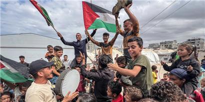 Palästinenser feiern im Lager Nusairat nachdem sich Israel und die Hamas auf die erste Phase eines Friedensplans zur Beendigung der Kämpfe geeinigt haben
