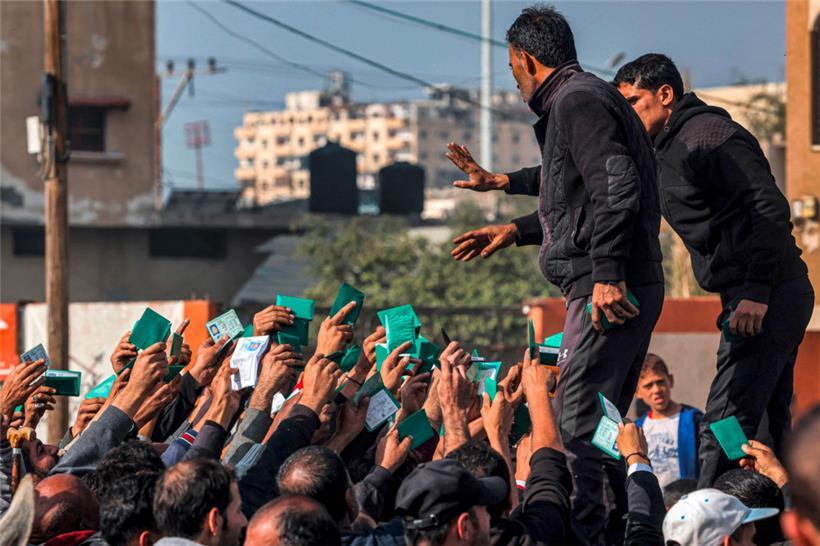 Palästinenser im Gazastreifen zeigen ihren Ausweis, um Mehl zu erhalten

