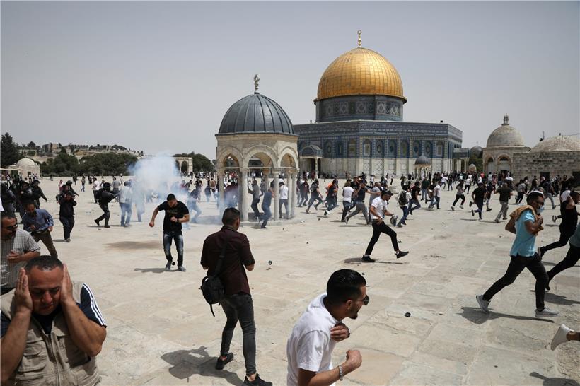 Palästinenser rennen vor Schallbomben weg, die von der israelischen Polizei vor dem Felsendom-Schrein im Al-Aksa-Moschee-Komplex geworfen werden
