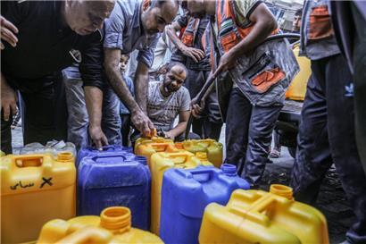 Palästinenser stehen Schlange, um Wasser zu bekommen, während der Krieg zwischen Israel und der Terrororganisation Hamas weitergeht
