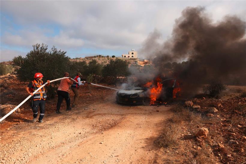 Palästinensische Feuerwehrleute löschen ein Fahrzeug, das von israelischen Siedlern im palästinensischen Westjordanland angezündet wurde, um die heimischen Bauern bei der Olivenernte zu stören
