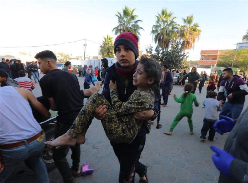 Palästinensische Gebiete, Dair El-Balah: Ein palästinensischer Junge bringt am 9.12. ein Mädchen, das bei israelischen Luftangriffen verletzt wurde, ins El-Aqsa Medical Krankenhaus.
