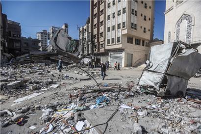 Palästinensische Gebiete, Khan Yunis, südlicher Gaza-Streifen: Palästinenser gehen an den Überresten von Gebäuden vorbei, die bei israelischen Luftangriffen zerstört wurden. Während Hunderttausende Palästinenser im Süden des Gazastreifens Schutz vor der erwarteten israelischen Bodenoffensive suchen, bombardiert Israels Luftwaffe nach eigenen Angaben weiter Hamas-Ziele. 
