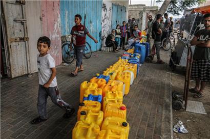 Palästinensische Gebiete, Rafah: Palästinenser warten inmitten der anhaltenden israelischen Bombardierung des Gazastreifens an einer Wasserverteilungsstelle, um ihre Wasserbehälter aufzufüllen.
