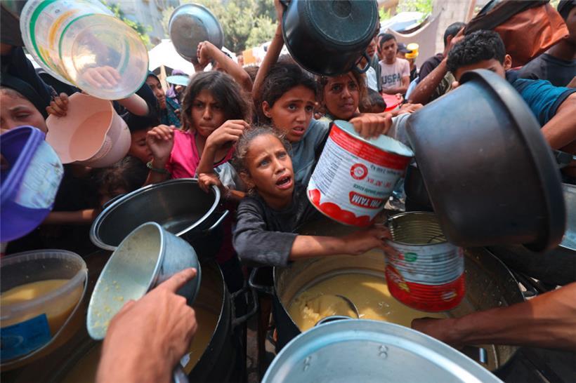 Palästinensische Kinder stehen an einer Essensausgabe Schlange, um eine warme Mahlzeit zu erhalten. Nach mehr als 20 Monaten verheerender Kämpfe sagen Menschenrechtsorganisationen, dass die über zwei Millionen Einwohner Gazas unter hungerähnlichen Bedingungen leiden.
