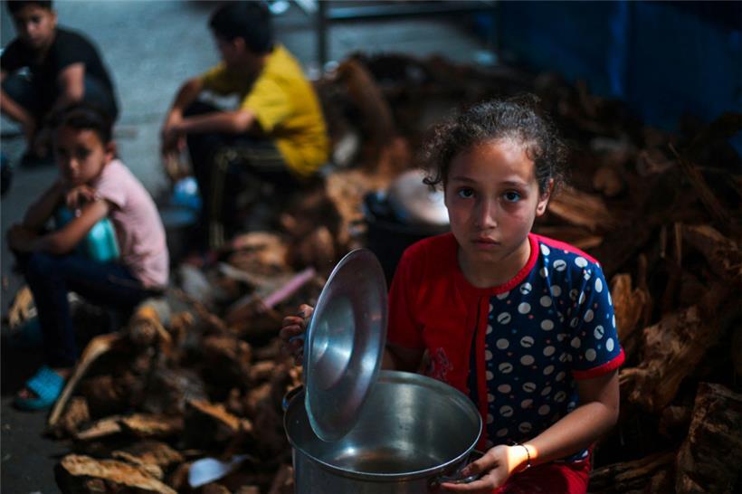 Palästinensische Kinder warten an einer Verteilungsstelle in Nuseirat im zentralen Gazastreifen auf Essen
