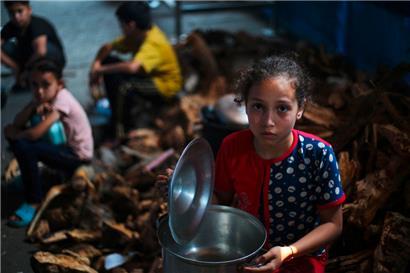 Palästinensische Kinder warten an einer Verteilungsstelle in Nuseirat im zentralen Gazastreifen auf Essen

