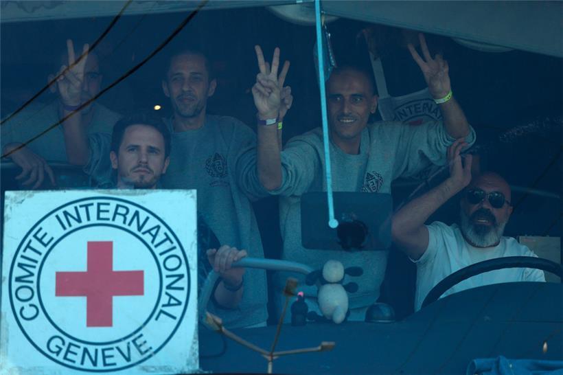 Palästinensische Männer winken nach ihrer Freilassung aus dem Militärgefängnis Ofer aus einem Bus heraus
