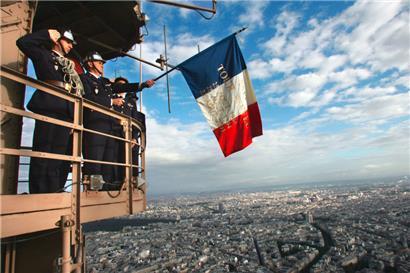Pariser Feuerwehrleute zeigen eine französische Nationalflagge auf dem Balkon des Eiffelturms am 25. August 2004 zum Gedenken an ihre Kollegen von 1944, die dies am Tag der Befreiung von Paris von der Nazi-Besatzung taten
