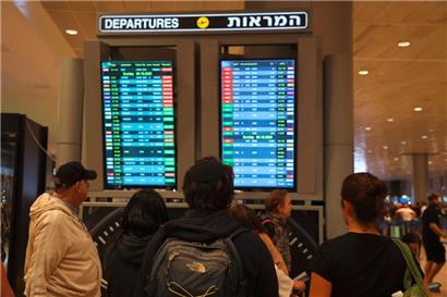 Passagiere schauen am 7. Oktober am Ben-Gurion-Flughafen nahe Tel Aviv auf eine Anzeigetafel – auf der einige Flüge gestrichen sind
