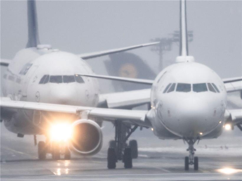 Passagierflugzeuge am Flughafen Frankfurt bei Sprühregen und Schneefall warten auf Startfreigabe