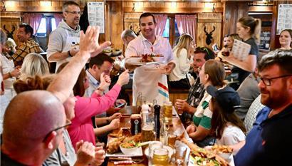 Paul Ruppert, Bürgermeister von Flaxweiler, bringt den traditionellen Fisch an die hungrigen Gäste
