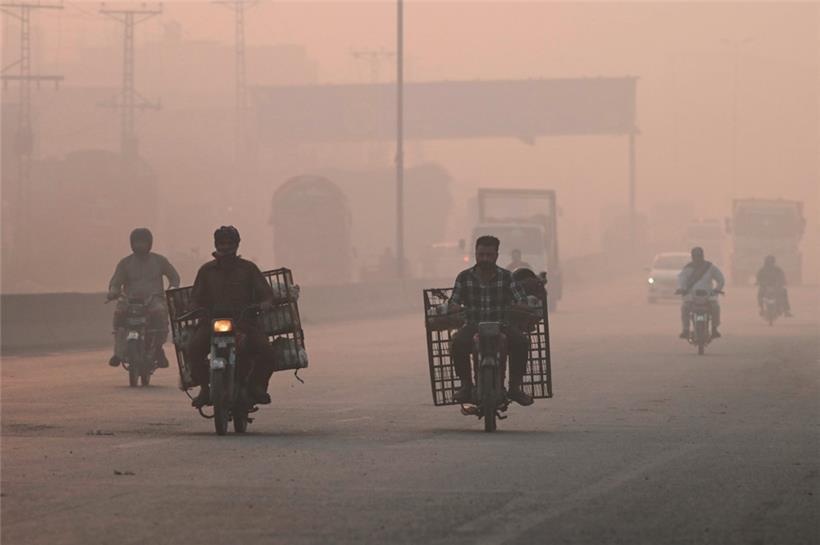 Pendler bahnen sich ihren Weg durch den Smog in Lahore
