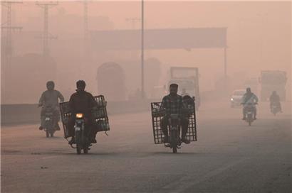 Pendler bahnen sich ihren Weg durch den Smog in Lahore
