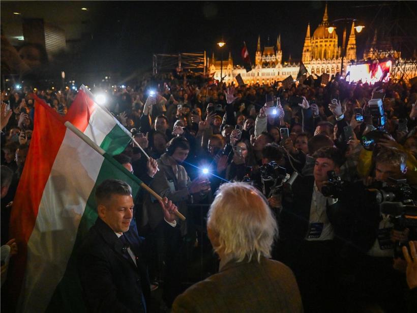 Péter Magyar (l.) hält eine Nationalflagge nach dem erdrutschartigen Sieg seiner Partei Tisza bei den Parlamentswahlen in Budapest