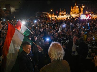 Péter Magyar (l.) hält eine Nationalflagge nach dem erdrutschartigen Sieg seiner Partei Tisza bei den Parlamentswahlen in Budapest