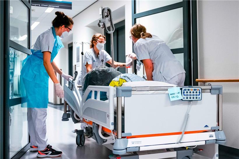 Pflegepersonal schieben das Bett mit einem Koronapatienten in der Kohortenabteilung des Catharina-Krankenhauses in Eindhoven, Niederlanden. Erst am 08.01.2021 sollen die ersten Personen gegen das Coronavirus geimpft werden. 
