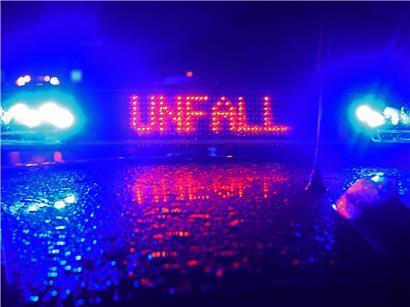 Polizei-Blaulicht leuchtet bei Unfallaufnahme auf Straße in der Nacht