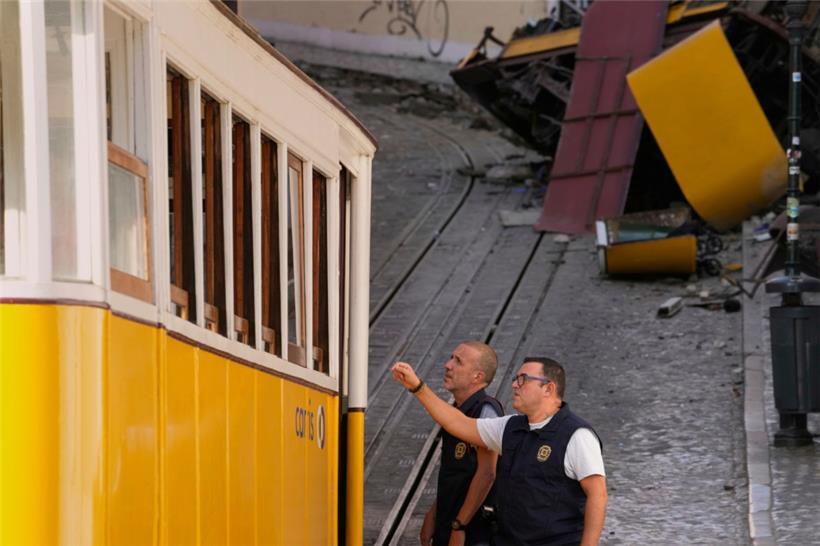 Polizeibeamte inspizieren kurz hinter der Unglücksstelle den unteren Waggon der Standseilbahn
