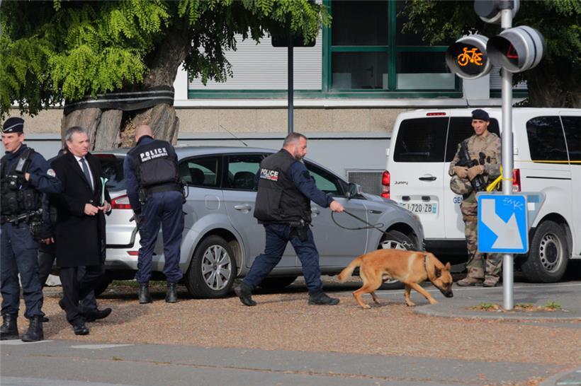 Polizeibeamte mit einem Spürhund treffen während eines Bombenalarms an einer Schule in Arras ein
