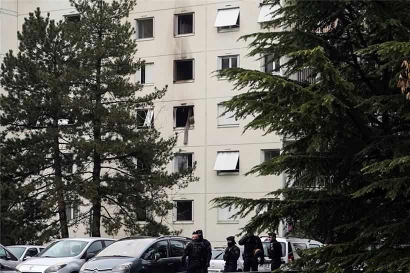 Polizeibeamte sichern eine Absperrung in der Nähe des Brandortes in einem Wohnhaus
