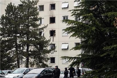Polizeibeamte sichern eine Absperrung in der Nähe des Brandortes in einem Wohnhaus
