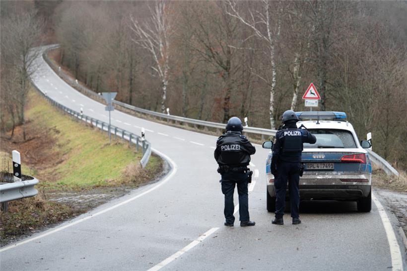 Polizeibeamte stehen an einer Absperrung an der Kreisstraße 22, rund einen Kilometer von dem Tatort entfernt, an dem zwei Polizeibeamte durch Schüsse getötet wurden
