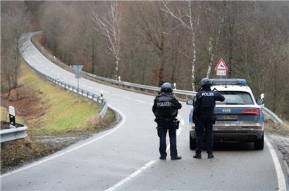 Polizeibeamte stehen an einer Absperrung an der Kreisstraße 22, rund einen Kilometer von dem Tatort entfernt, an dem zwei Polizeibeamte durch Schüsse getötet wurden
