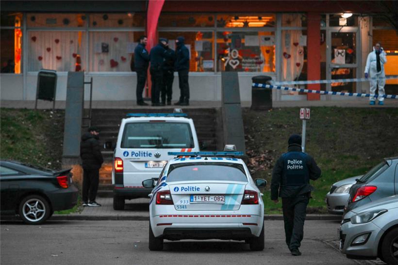 Polizeibeamte stehen in der Nähe einer Polizeiabsperrung (R, hinten) in einem Ermittlungsbereich im Viertel „Cite du Peterbos“, wo in der Nacht zum 7. Februar 2025 ein Mann bei einer neuen Schießerei im Zusammenhang mit Drogenhandel in der Gemeinde Anderlecht (Brüssel) getötet wurde
