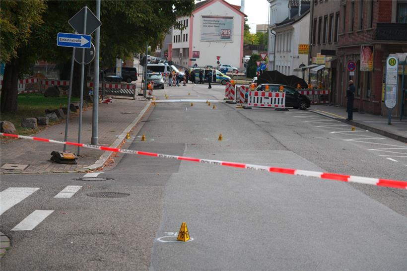 Polizeibeamte untersuchen das Umfeld eines Tatorts
