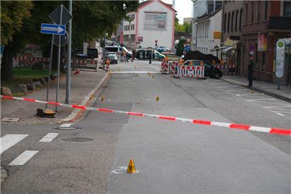 Polizeibeamte untersuchen das Umfeld eines Tatorts

