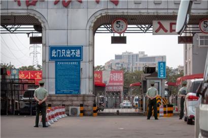 Polizisten halten vor den barrikadierten Eingängen des Xinfadi-Großmarktes Wache. Auf einem Großmarkt der chinesischen Hauptstadt wurden bei anfangs 500 Tests schon 45 Infektionen entdeckt.
