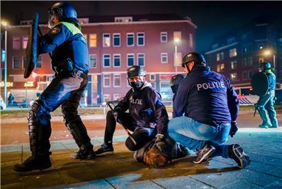 Polizisten nehmen in Rotterdam einen Demonstranten fest
