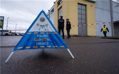 Polizisten sichern mit einer Drohne und einer Spezialkamera Bereiche eines Tatorts um die Trierer Diskothek
