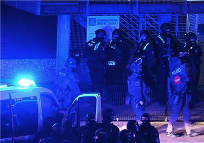 Polizisten sind in Hamburg im Einsatz und stehen vor einem Schild mit der Aufschrift „Königreichssaal Jehovas Zeugen“
