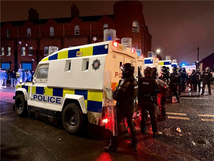 Polizisten stehen auf der Springfield Road in Belfast: In der britischen Provinz Nordirland kommt es seit Tagen zu nächtlichen Krawallen
